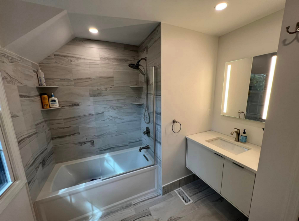 Updated bathroom with tile, bathtub, vanity